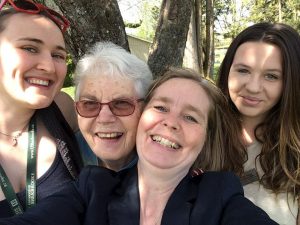 Image of four women aged from their late teens to their 70s, smiling at the camera.